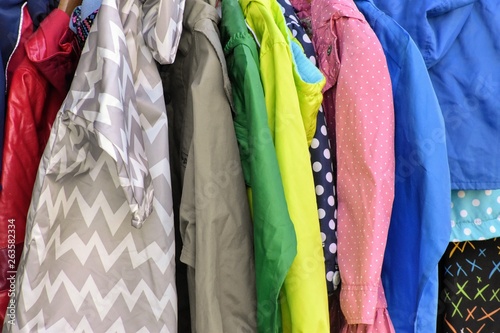 Colorful rack of jackets for sale on hangers, green, yellow, blue, zigzag, polka dot patterns.