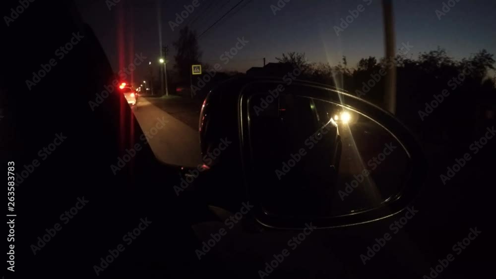 The cars with lights switched on are driving along the highway at night. The cars with lights switched on are driving along the highway at night.