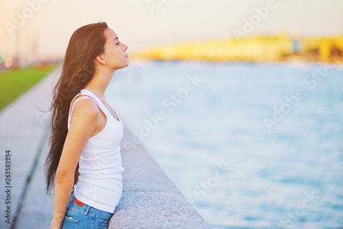 Side view profile portrait of a happy brunette woman relaxing breathing fresh air outdoors in summer Girl with long hair doing deep breath exercises. Positive emotion enjoy, peaceful freedom concept.