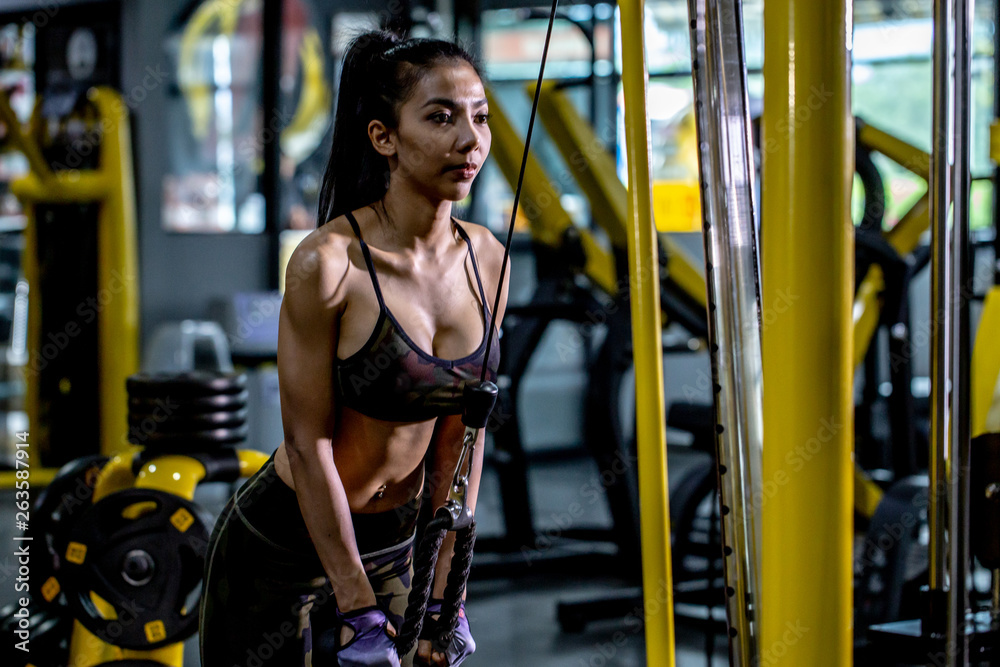 A sexy Asian girl is exercising in the gym with sling machine. Stock Photo  | Adobe Stock
