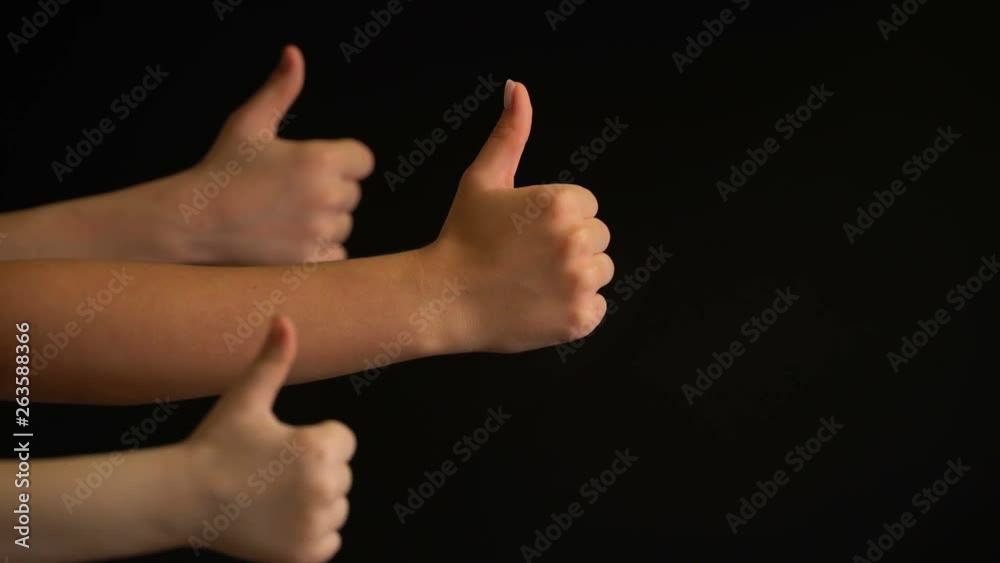 Raising hands with thumbs up on black background. Raising hands with thumbs up on black background.