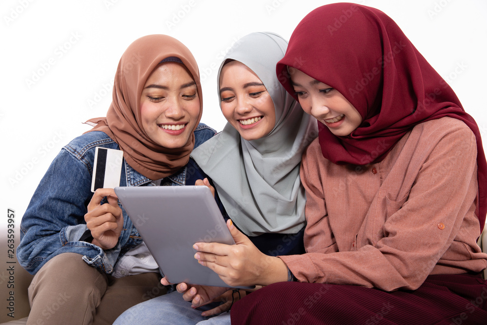 online shopping young muslim friend using credit card and tablet over white background online shopping young muslim friend using credit card and tablet over white background