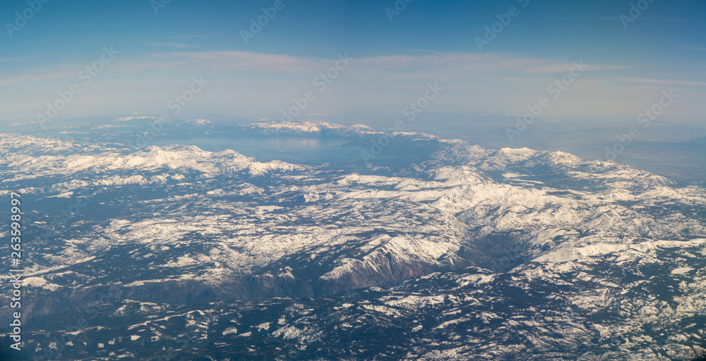 Fototapeta premium Wide Angle View of Large Lake Surrounded by Snowed Peak Mountains