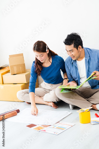 Asian couple choosing colour palette for their new house, lifestyle concept.