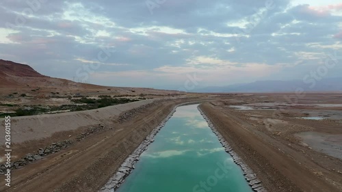 Israel, Turkiz color channel of water by the Deadsea sky reflection, Drone Shot Forward and up movment. photo