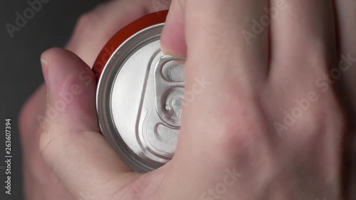 top view of white man open red can of soda or beer. unhealthy eating. hand opening. Slow motion video medium extreme close up high angle telephoto lens audio sound of the opening drink