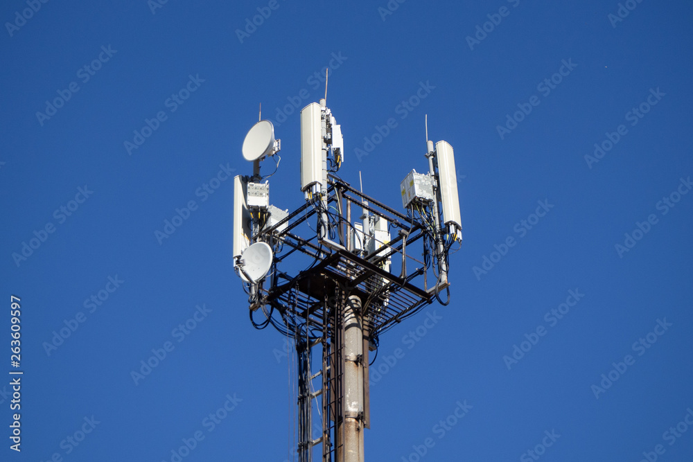 Cell phone telecommunication tower. Repeater. Against the blue sky. Close-up. Cell phone telecommunication tower. Repeater. Against the blue sky. Close-up.