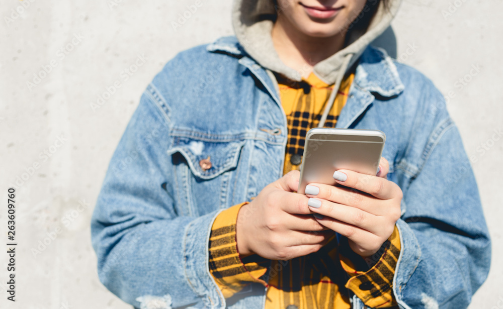 Fototapeta premium Young female using his smartphone on the street. Woman texting on her phone