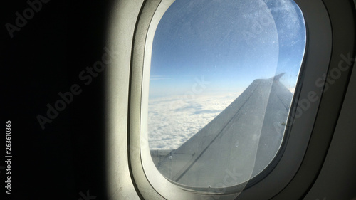 Clouds and sky as seen through window of an aircraft