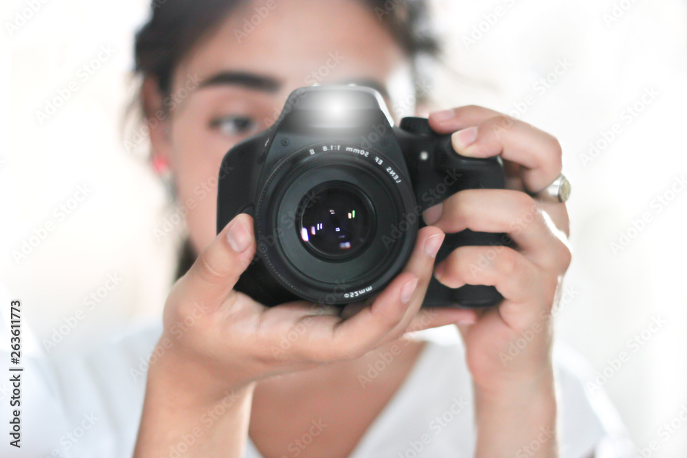 woman holding a photo camera and taking a picture with flash woman holding a photo camera and taking a picture with flash