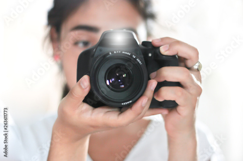 woman holding a photo camera and taking a picture with flash 