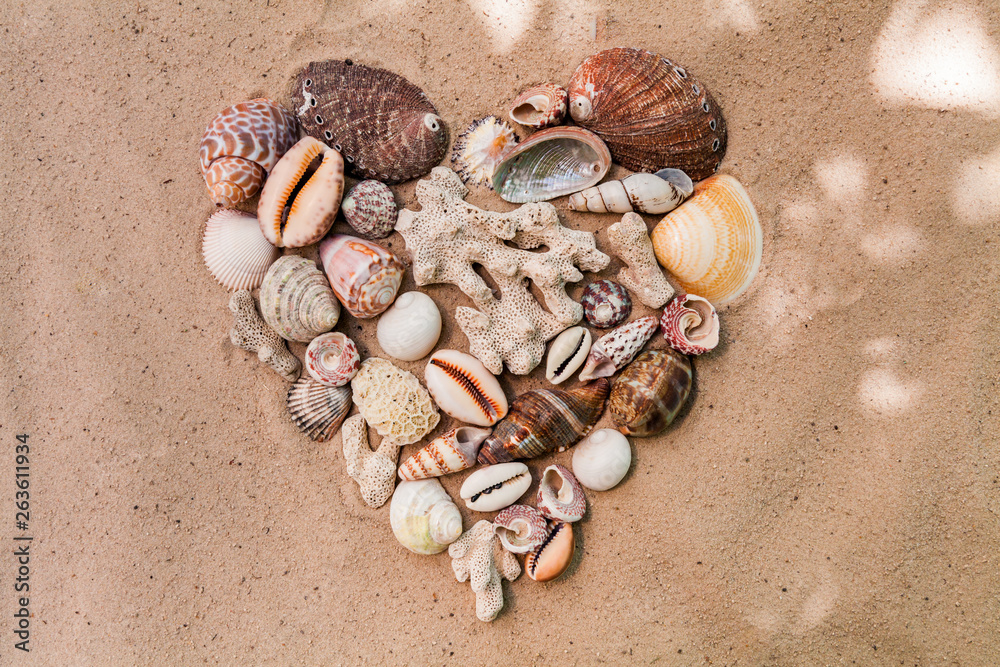 Heart of sea shells on a sandy beach. Background