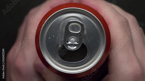 top view of white man open red can of soda or beer. unhealthy eating. hand opening. Slow motion video medium extreme close up high angle telephoto lens audio sound of the opening drink