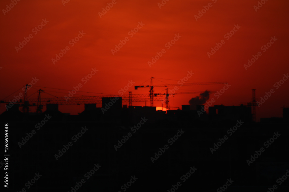 Sunrise Peaking Behing a Construction Crane