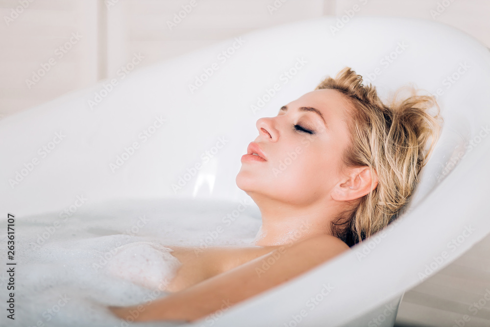Naklejka premium Blonde woman relaxing in bath
