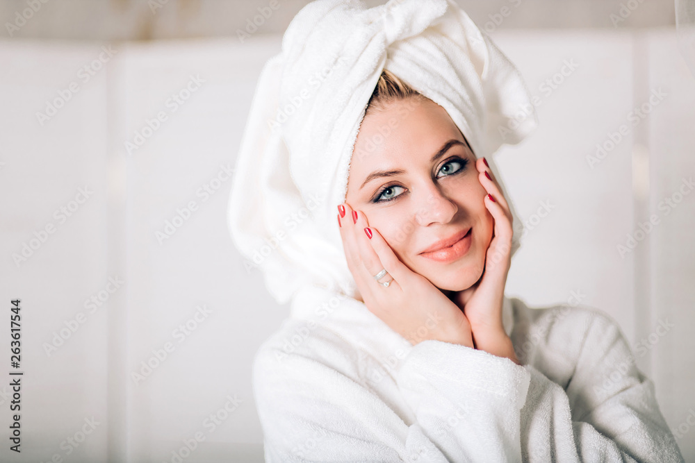 Young smiling woman in bathrobe with towel on head Young smiling woman in bathrobe with towel on head