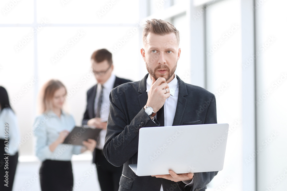 businessman with laptop on the background of the office lobby. businessman with laptop on the background of the office lobby.
