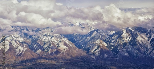 Aerial view from airplane of the Wasatch Front Rocky Mountain Range with snow capped peaks in winter including urban cities of Provo, Farmington Bountiful, Orem and Salt Lake City. Utah. United States