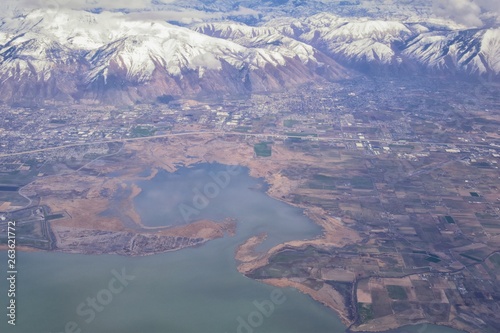 Aerial view from airplane of the Wasatch Front Rocky Mountain Range with snow capped peaks in winter including urban cities of Provo, Farmington Bountiful, Orem and Salt Lake City. Utah. United States