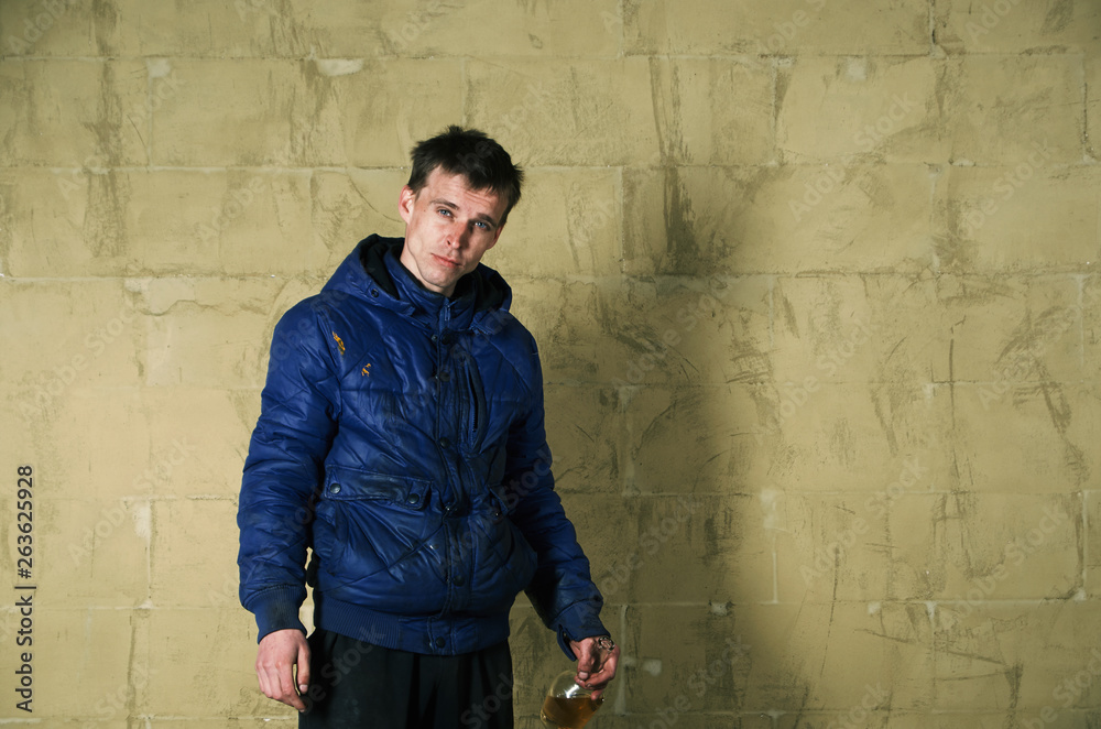 A disheveled man with alcohol in his hand.