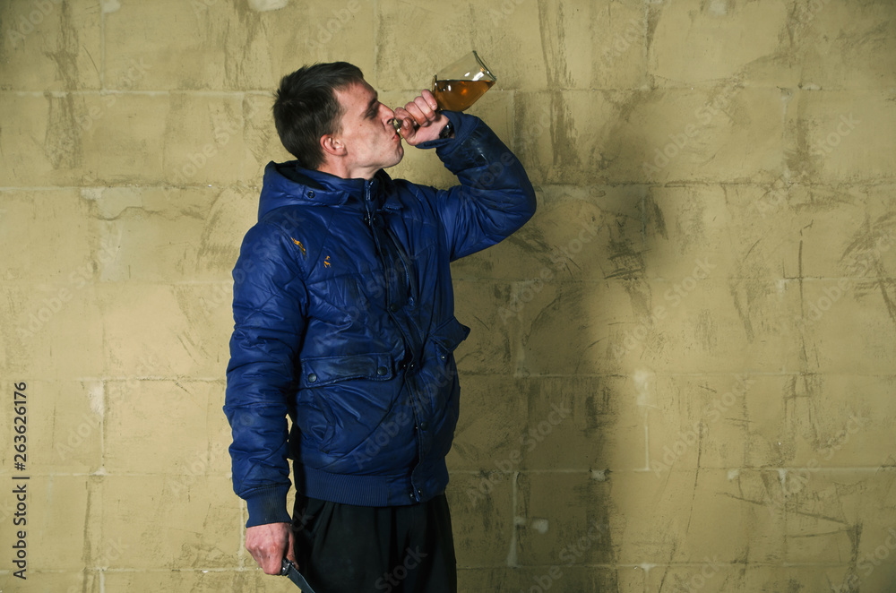 A disheveled man with alcohol in his hand. A disheveled man with alcohol in his hand.