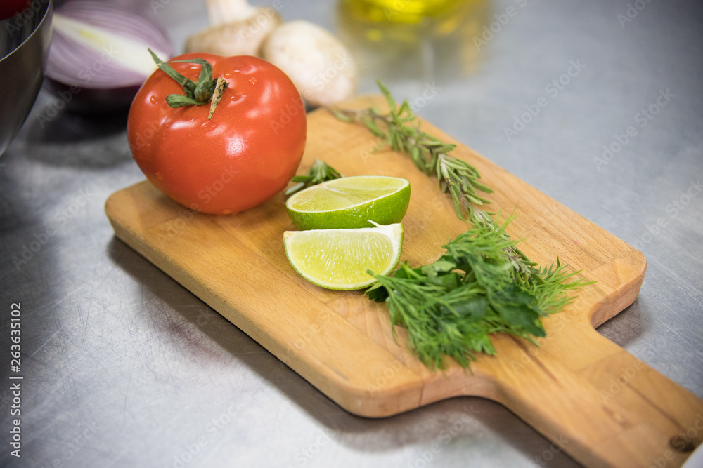 Restaurant kitchen. A tomato and lime on the desk