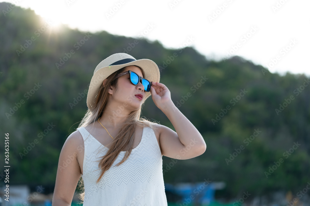 Beach vacation,young woman in sunhat enjoying looking view of beach ocean on hot summer day. 