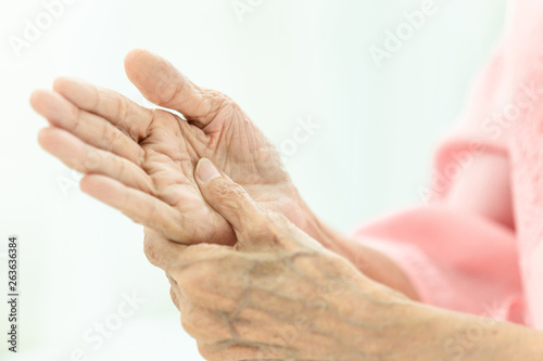 Asian senior woman is massaging her own hand,Elderly woman suffering from pain in hand,arthritis,beriberi
