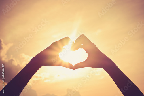 Hand in shape of heart for love and have sun light in centre.