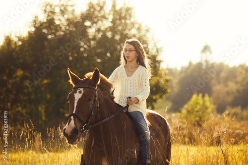 Young girl goes sorrel horse riding © Olga
