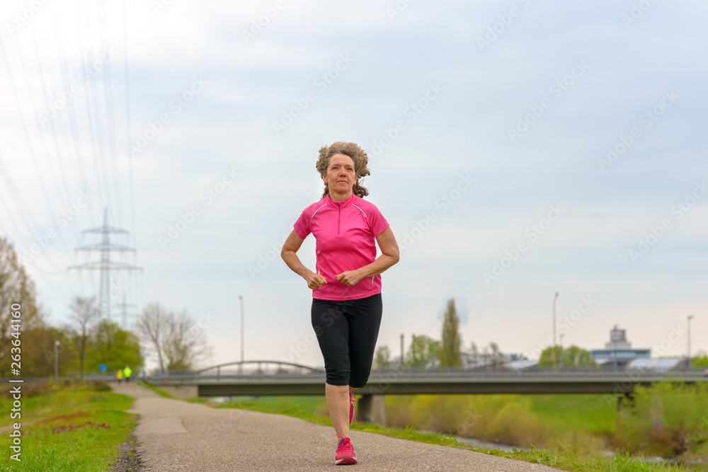 Middle age woman running outdoors