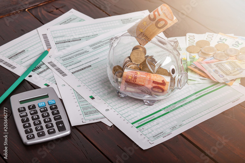 Konzept Steuern mit Geld Taschenrechner und Sparschwein photo