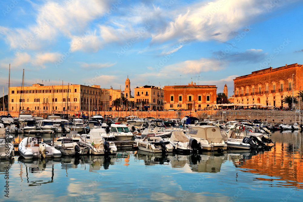 Trani, Italy - Panoramic view of the Trani Adriatic Sea yacht port and marina with boats and yachts docked at the piers circled with the Via Statuti Maritimi promenade.