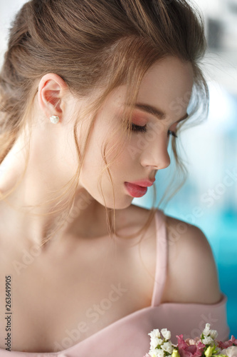 Beauty portrait of a cute young girl with a gentle make-up and light air hairstyle.