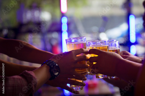 Group of  young people hands toasting and cheering aperitif beers half pint