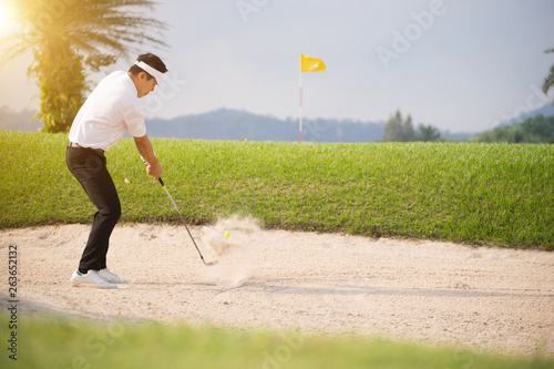 Golfer's golfing in the bunker amid the warm sunlight in the morning.