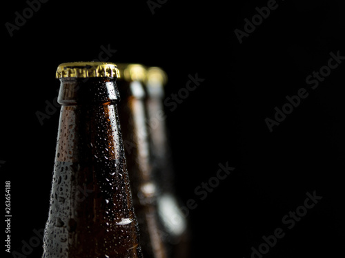 Group of beer glass bottles on dark background