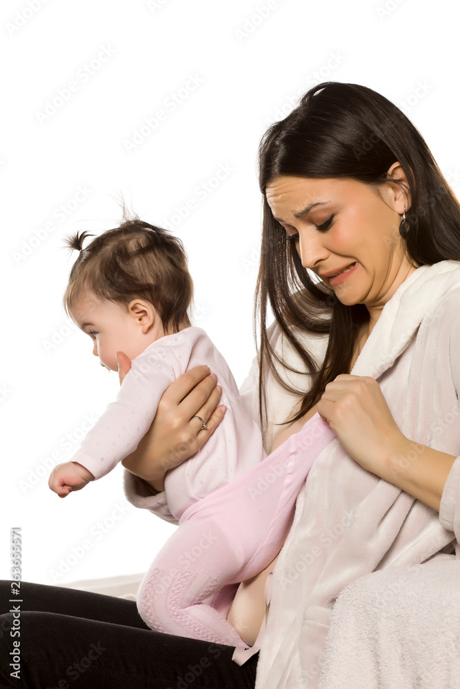 a young mother checks her baby's nappy a young mother checks her baby's nappy