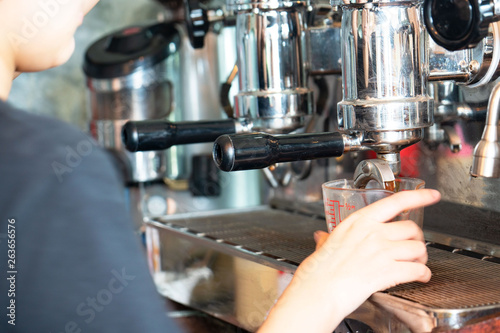 coffee machine preparing fresh coffee at coffee shop .