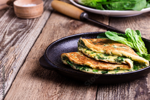 Spinach omelette in cast iron skillet, healthy vegetarian breakfast