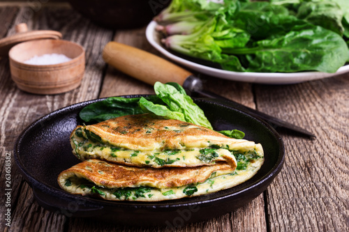 Spinach omelette in cast iron skillet, healthy vegetarian breakfast photo