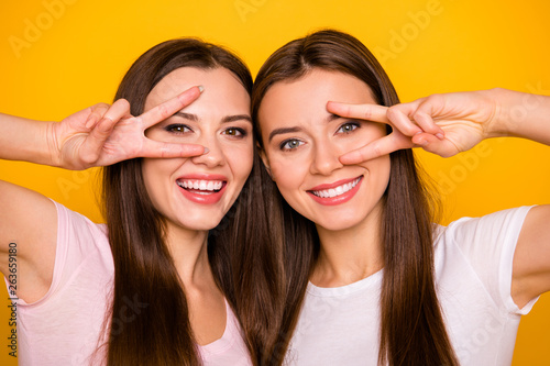 Close up photo of charming cute lovely best fellows fellowship make v-signs near face feel glad excited candid travel have free time weekends wear pastel clothing isolated on vibrant background