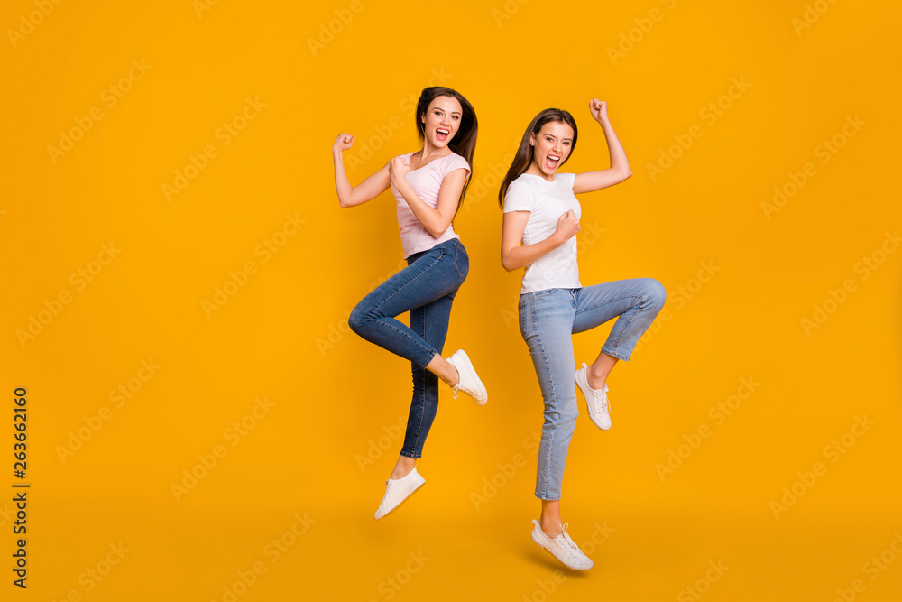 Full length body size view portrait of nice charming attractive cheerful overjoyed satisfied slim fit straight-haired girls having fun victory triumph isolated on bright vivid shine yellow background