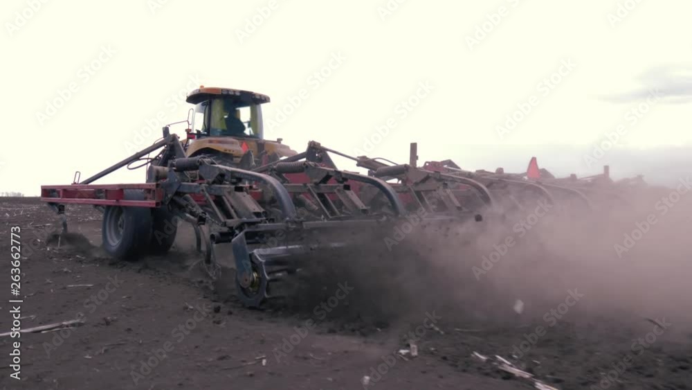 process plowing farming land at spring, modern tractor working on agricultural field close up with dust process plowing farming land at spring, modern tractor working on agricultural field close up with dust
