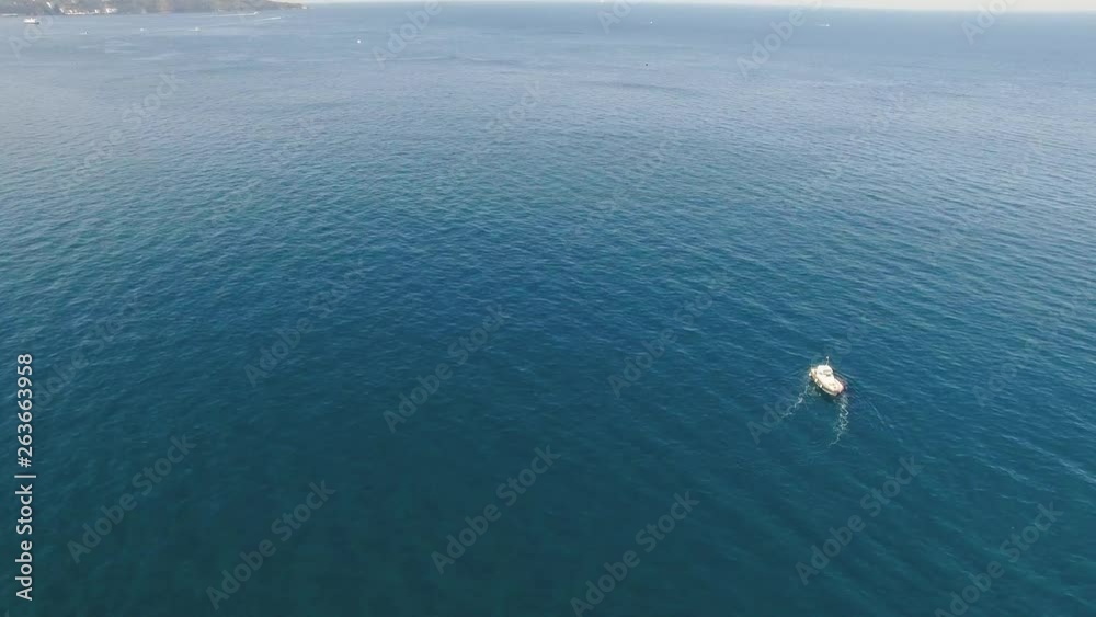 Fishing boat floating on the water, blue sea and sky with copyspace Fishing boat floating on the water, blue sea and sky with copyspace