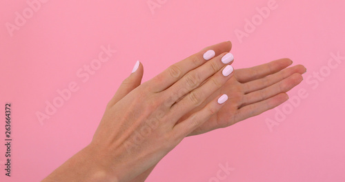 Woman hands clapping applause isolated over pastel pink background in studio