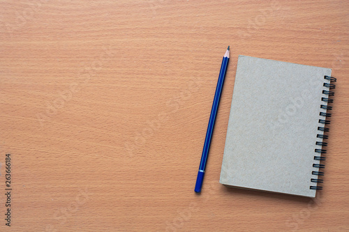 Notepad with pencil on wood board background.using wallpaper for photo