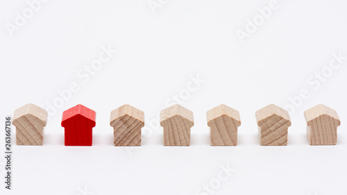 Bild auf Leinwand Rangée de petites maisons en bois, une d'entre elles peinte en rouge, fond blanc