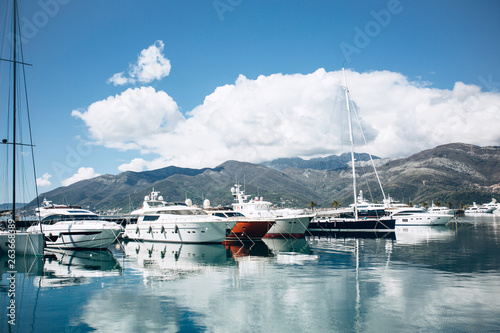 Many yachts moored at the coast in Porto Montenegro in Tivat in Montenegro against the backdrop of a beautiful mountain landscape. Summer sea vacation