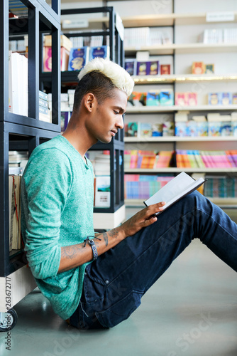 Black student reading interesting book 